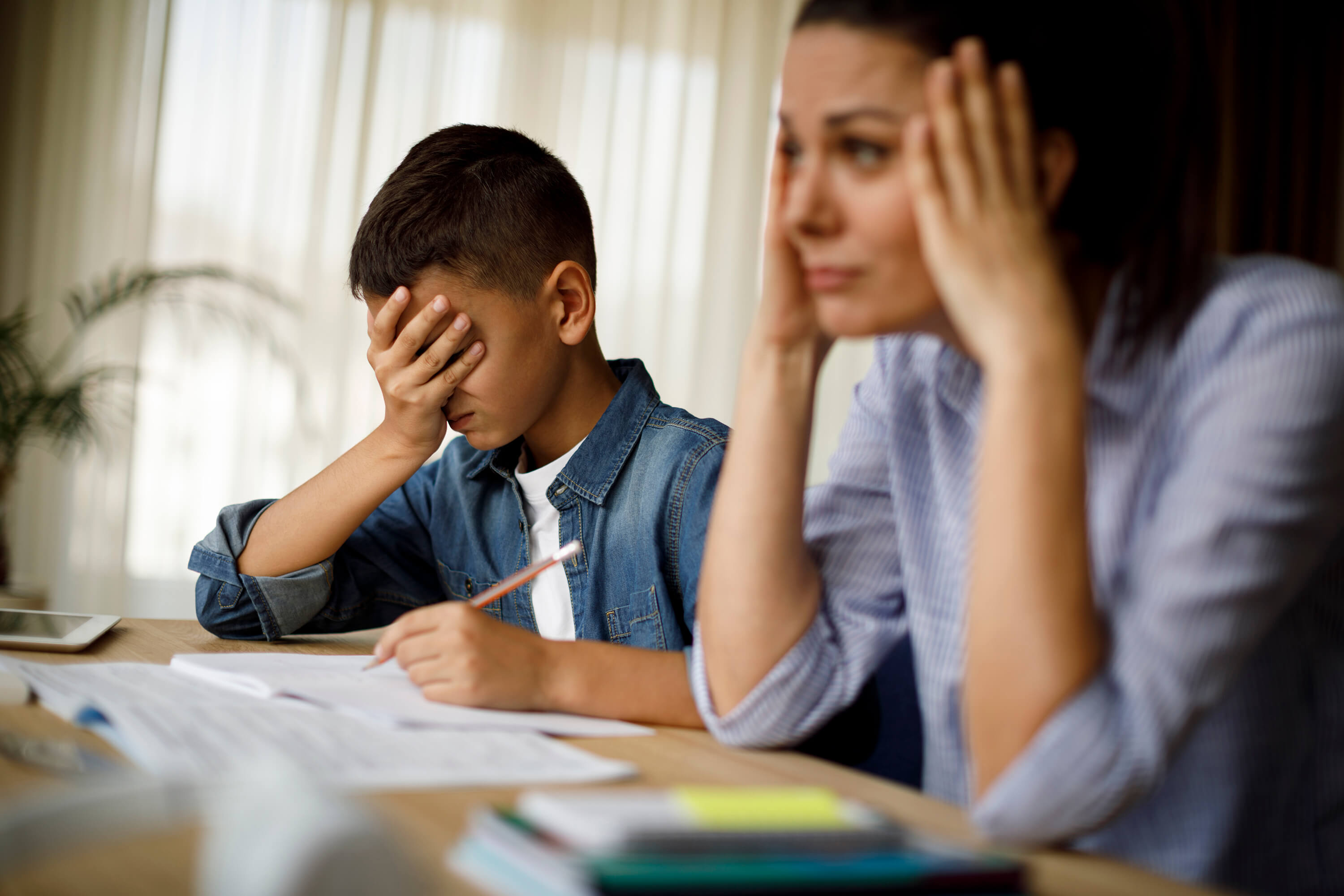 Parent and child looked stressed doing schoolwork.