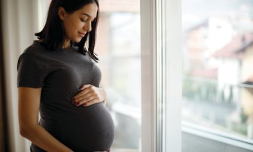 An expecting mother looking down at her belly