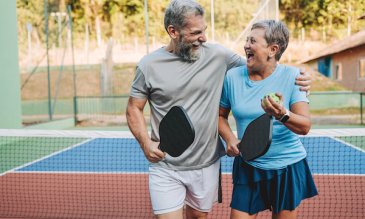 A man and woman playing pickleball
