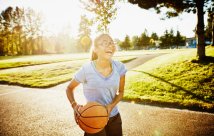 A teen girl holding a basketball